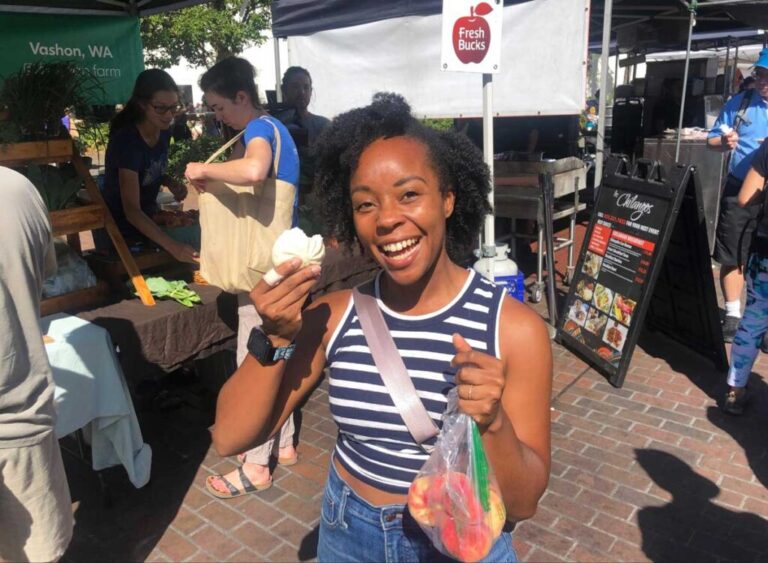 The author Chelsea Booker holding a bun in Ballard Famers Market