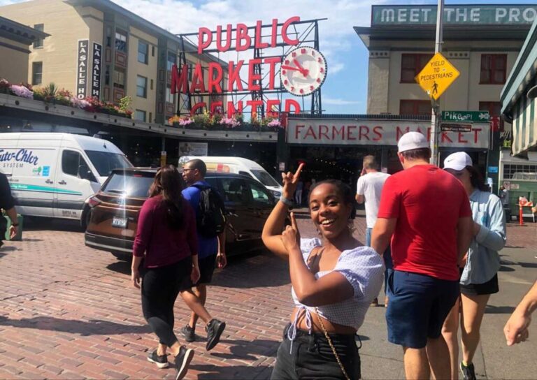 The author Chelsea Booker pointing the Public Market Center signage