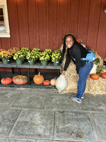 The author Chelsea Booker picking a pumpkin at Bayview Garden