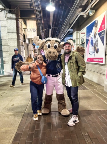 The author Chelsea Booker and her husband, posing with the Moose mascot