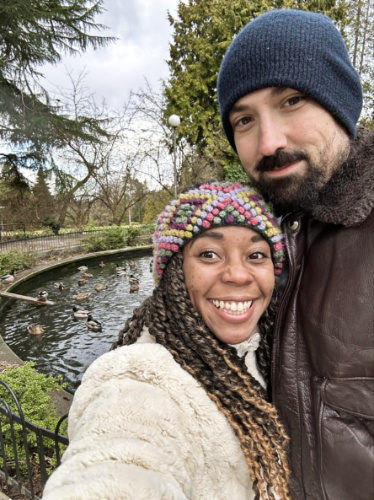 The author Chelsea Booker and her husband taking a photo with the ducks in the pond