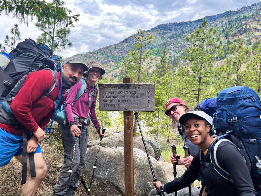 The author Chelsea Booker and her family smiling for a photo in front of the Lakeshore Trail sign