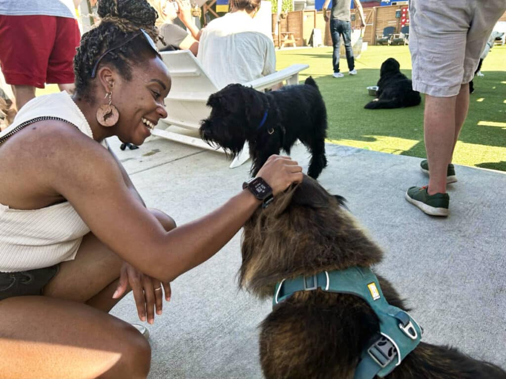 The author Chelsea Booker, petting the dog in Dog Yard Bar