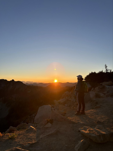 The author Chelsea Booker enjoying the sunrise on Dege Peak