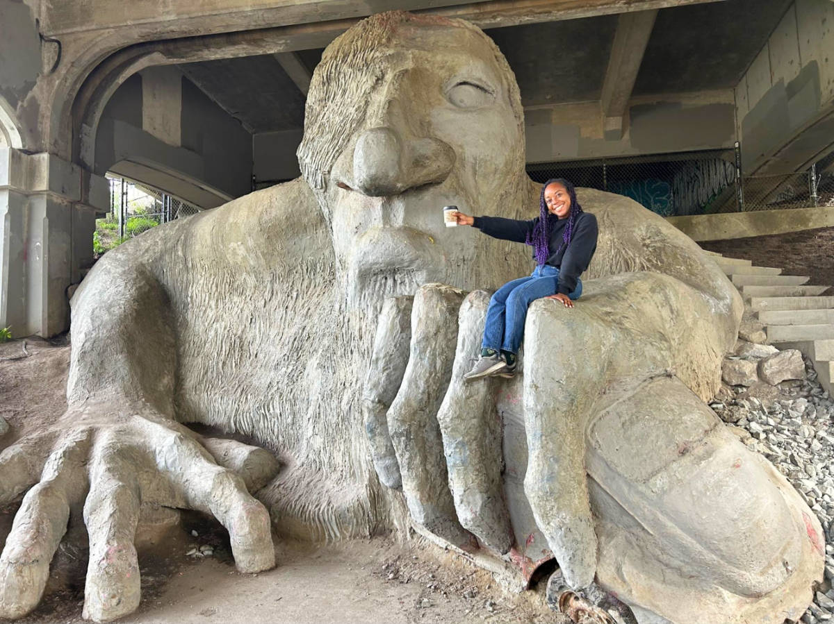 The author Chelsea posing with a coffee on the Fremont Troll