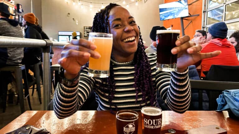 The author Chelsea Booker holding her favorite beers from a beer flight at Jellyfish Brewing Co