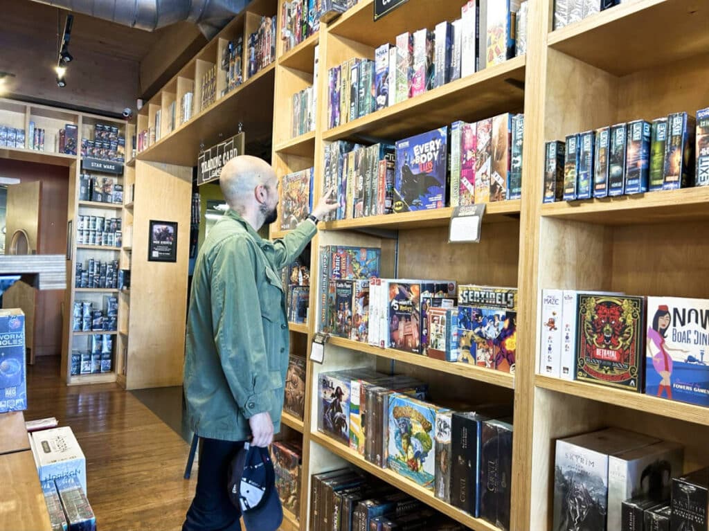 The author Chelsea Booker's husband browsing the games at Mox Boarding House