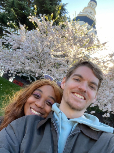 The author Alexandria Taylor with her partner and a cherry blossoms tree
