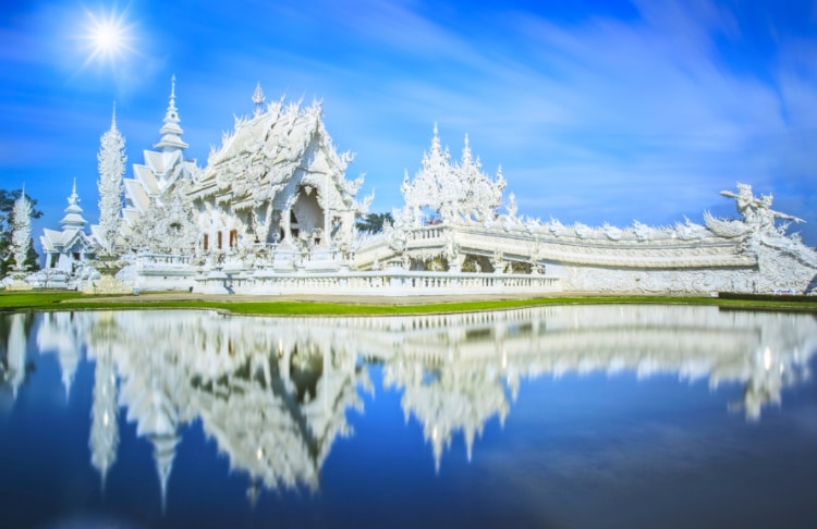 View of the stunning white temple in Chiang Rai, reflecting on the water