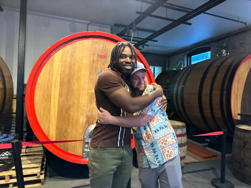 Two people smiling and hugging for a photo during the Travel Lemming's Chicago Community Meetups