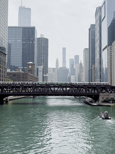 A train crossing the bridge over the river with a cruise