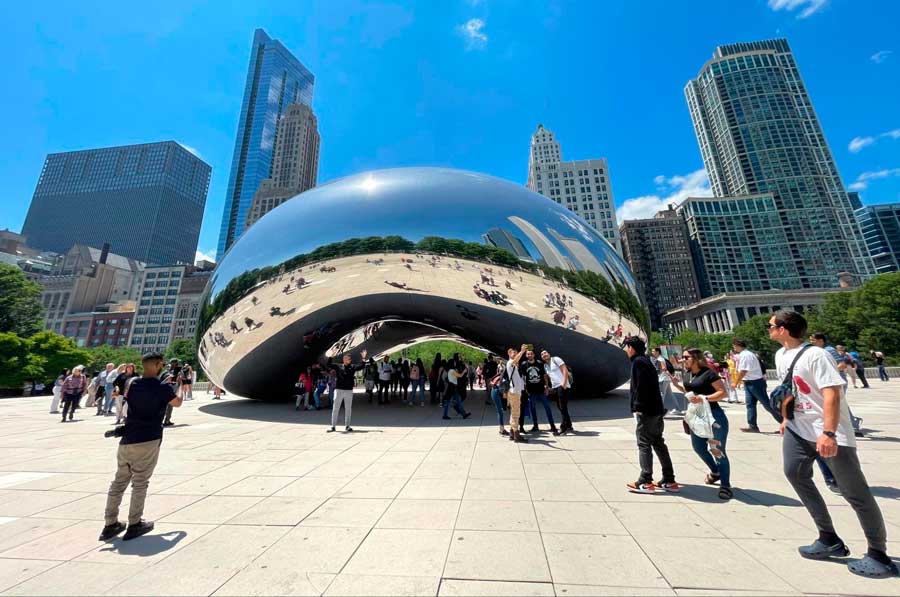 People posing for a photo with the Cloud Gate in Millennium Park