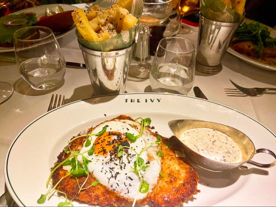A plate of Chicken Milanese with a truffle cream sauce and truffle chips on the side at The Ivy Chelsea Garden