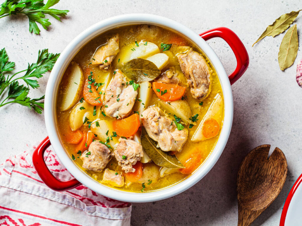 Top view of the Pollo Guisado with potatoes and carrots in a red pot