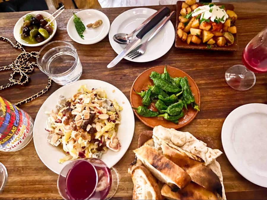A table full of Chicory salad, padron peppers, patatas bravas, and some bread at Morito Exmouth Market