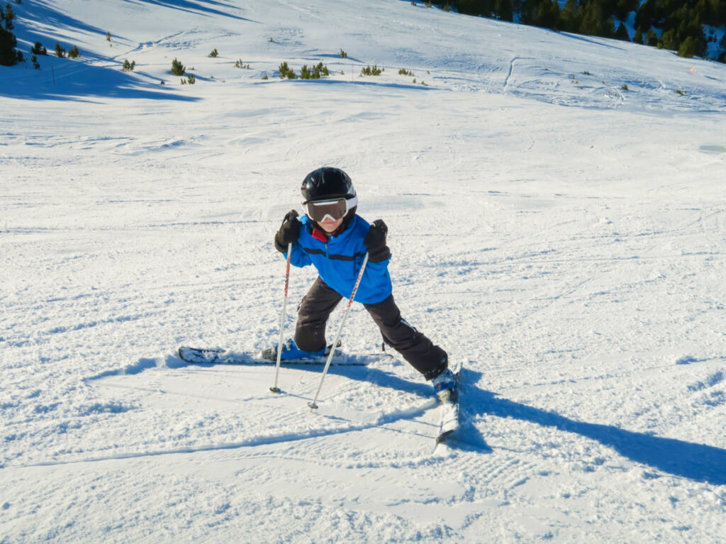 A child learning to ski on a slope