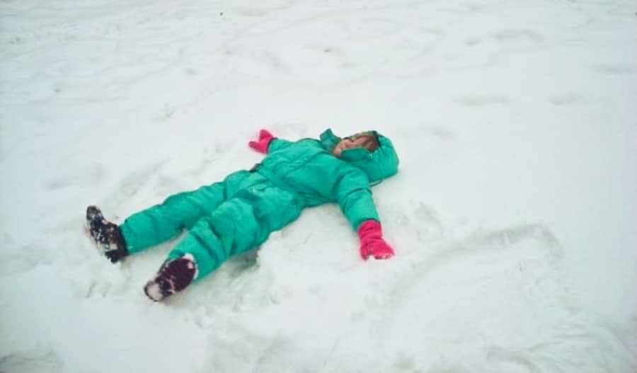 A child lying on the snow and making a snow angel