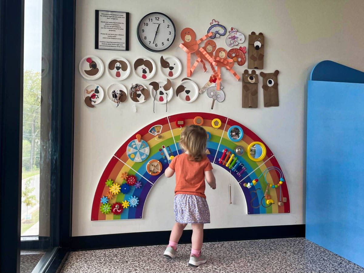 A child playing with the colorful and interactive wall decor