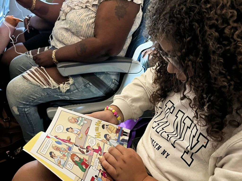 A child reading a book in the plane
