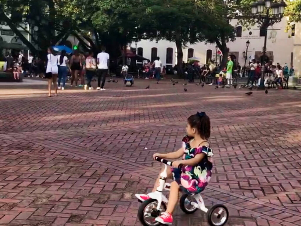 A child riding her tricycle in Parque Colon