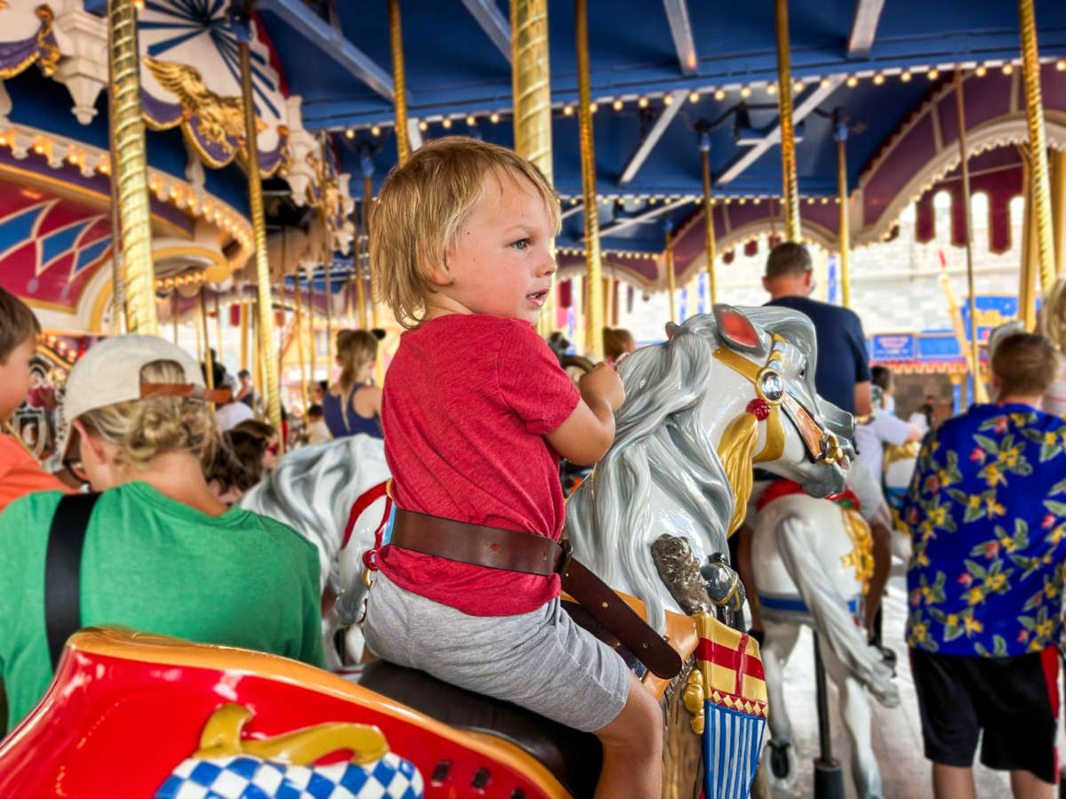 A child riding the Prince Charming Regal Carrousel