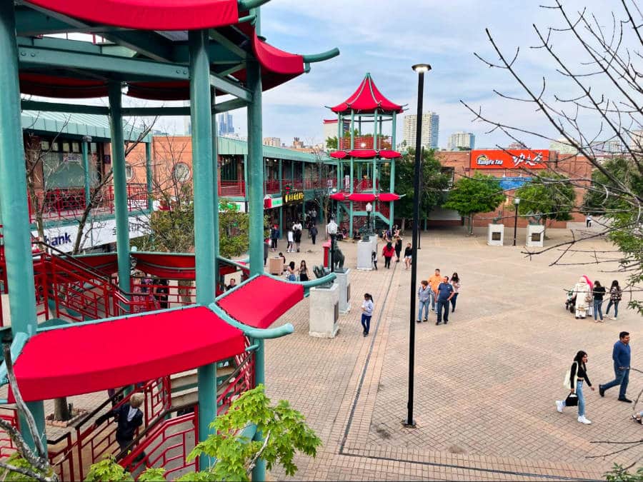 People walking around the two Chinese-inspired towers surrounded by different shops at Chinatown Square in Chicago