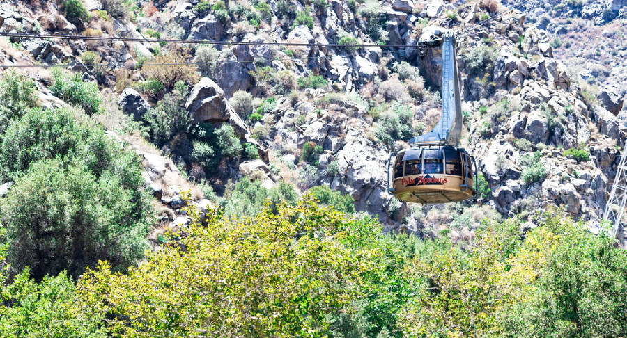 An aerial tram with passengers moves through Chino Canyon in the San Jacinto Mountains.