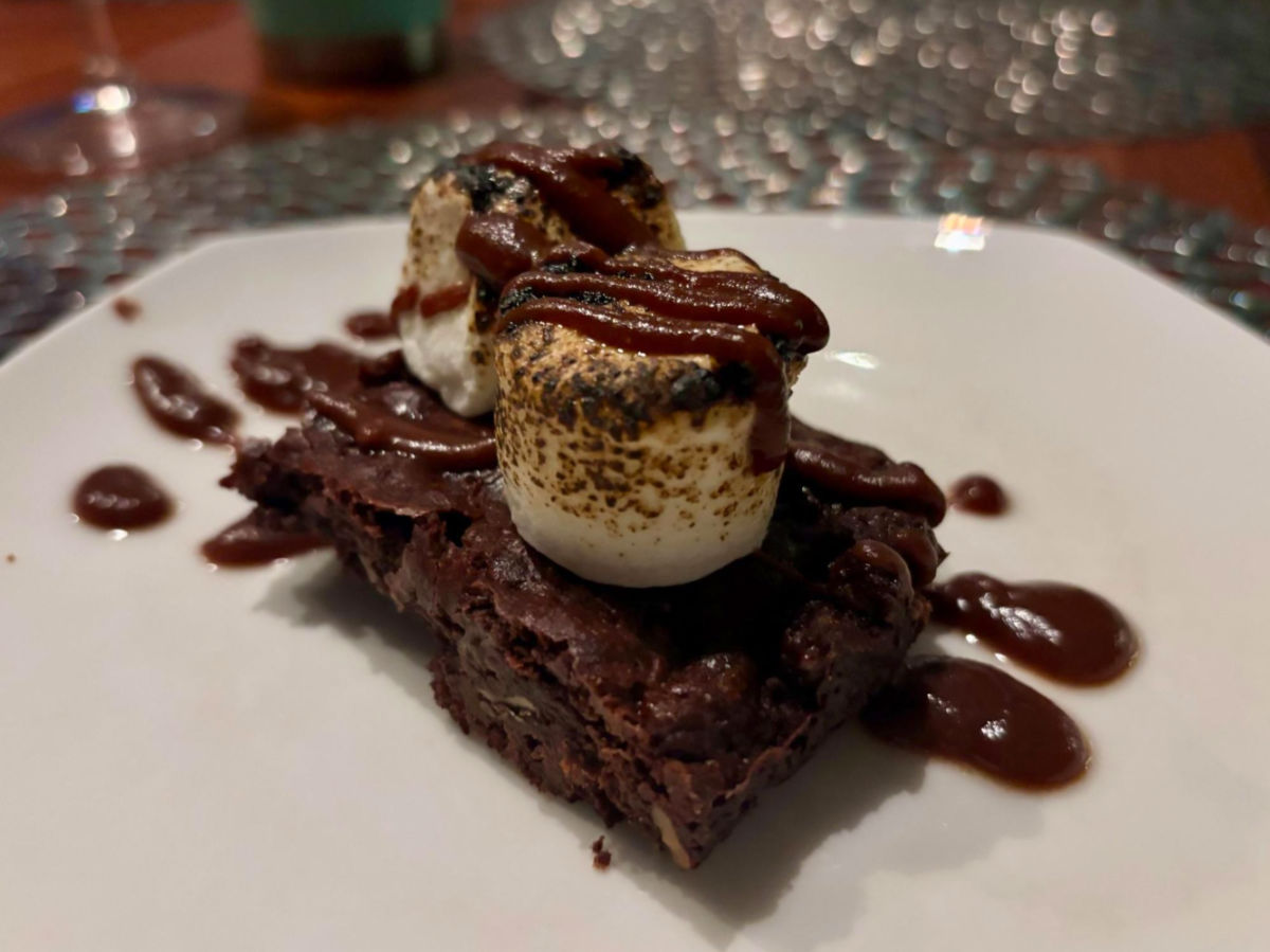A chocolate brownie topped with two toasted marshmallows