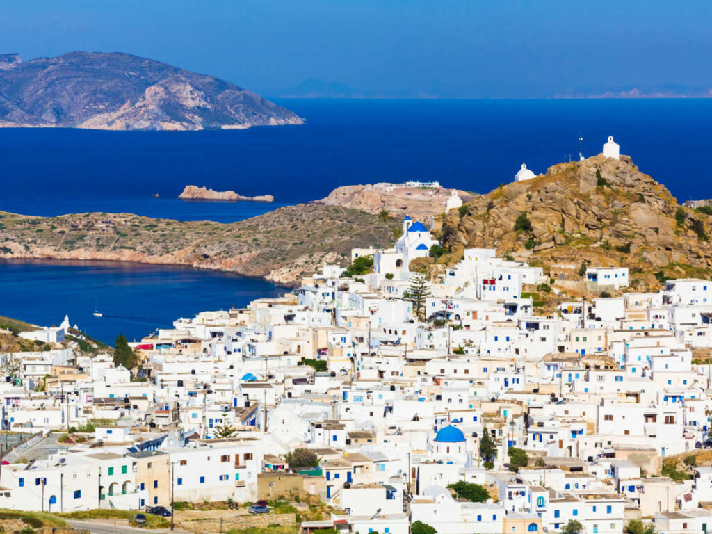 Aerial view of the white buildings in Chora Town with the deep blue Aegean Sea in the background