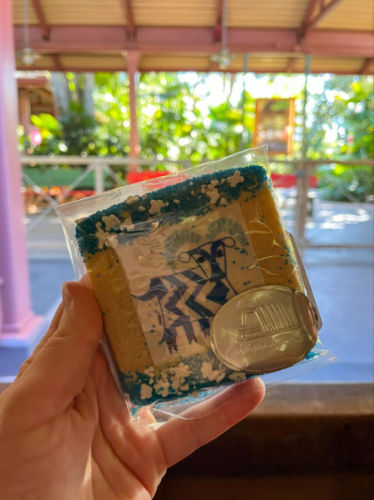 Holding a Christmas cookie from the themed Holidays Kitchens at Epcot