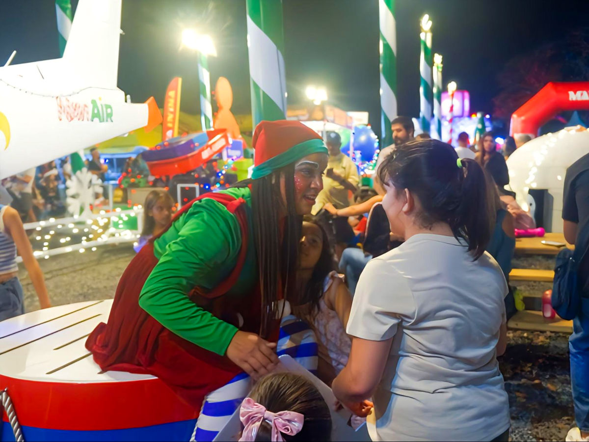 Christmas worker with children at Christmas parade in Navitown in San Juan