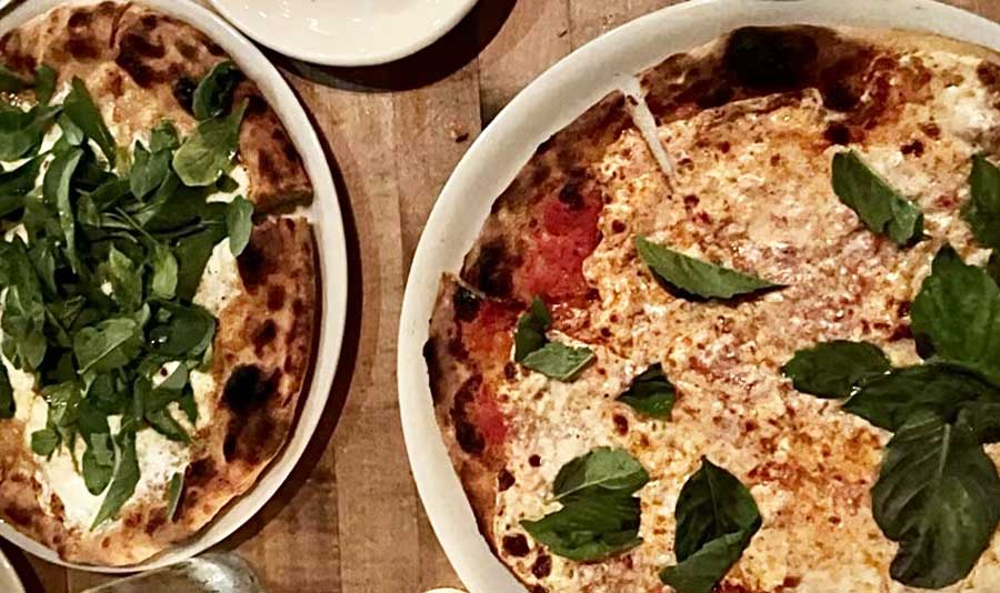 Two whole pizza on a plate in Cibo Pizzeria