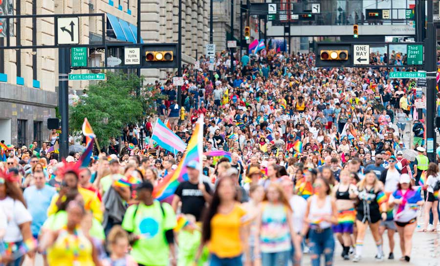 People with rainbow flags at a parade during the Cincinnati Pride Festival