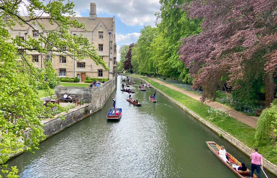 People riding a boat on a river in the City of Cambridge