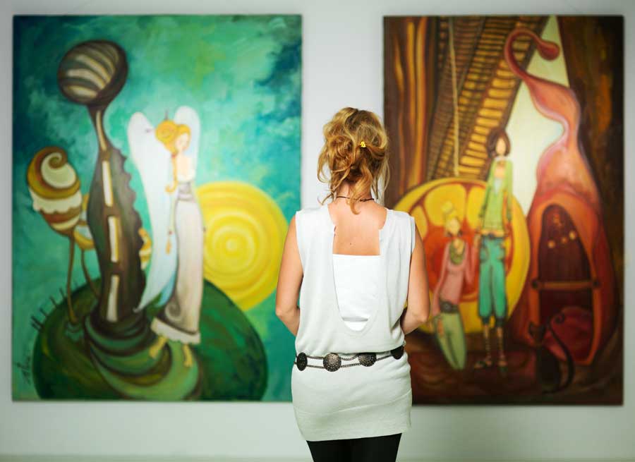 A woman admiring paintings inside an art gallery