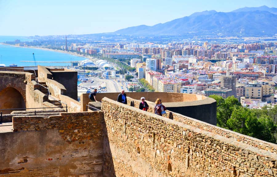 People walking along the narrow bridge with a scenic cityscape view from Castillo de Gibralfaro 