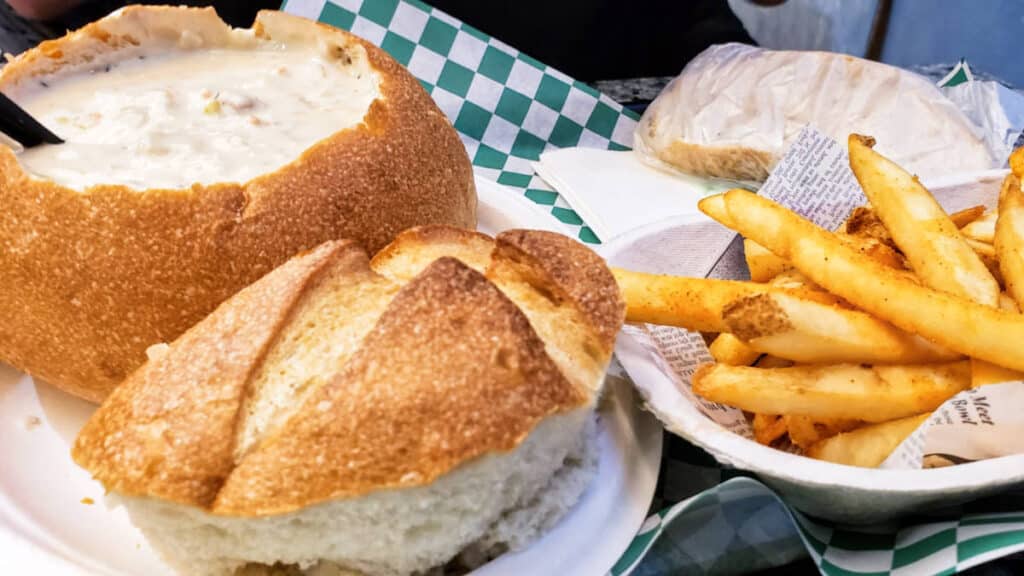 View of a bread bowl clam chowder with fries on the side