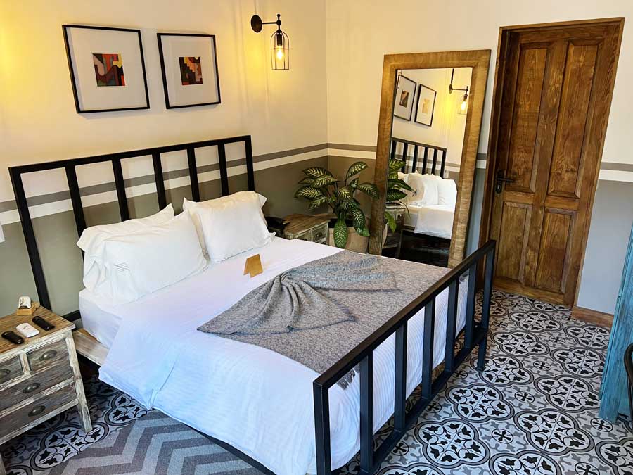 View of a bed with a big mirror on the side in Clandestino Hotel Recreo