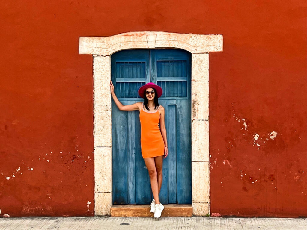 Clara Kesseler posing for a photo on a Red Wall Valladolid, Mexico