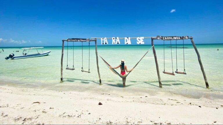 Travel Lemming writer Clara Kessler on a swing on the shoreline in Isla Holbox