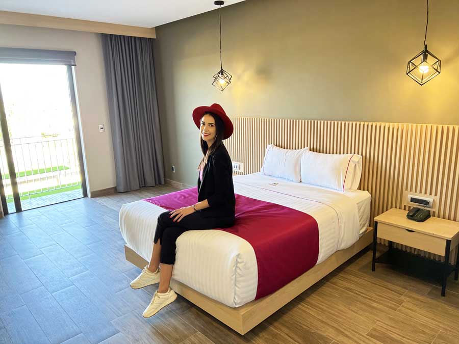 Clara sitting on a bed in Hotel MX
