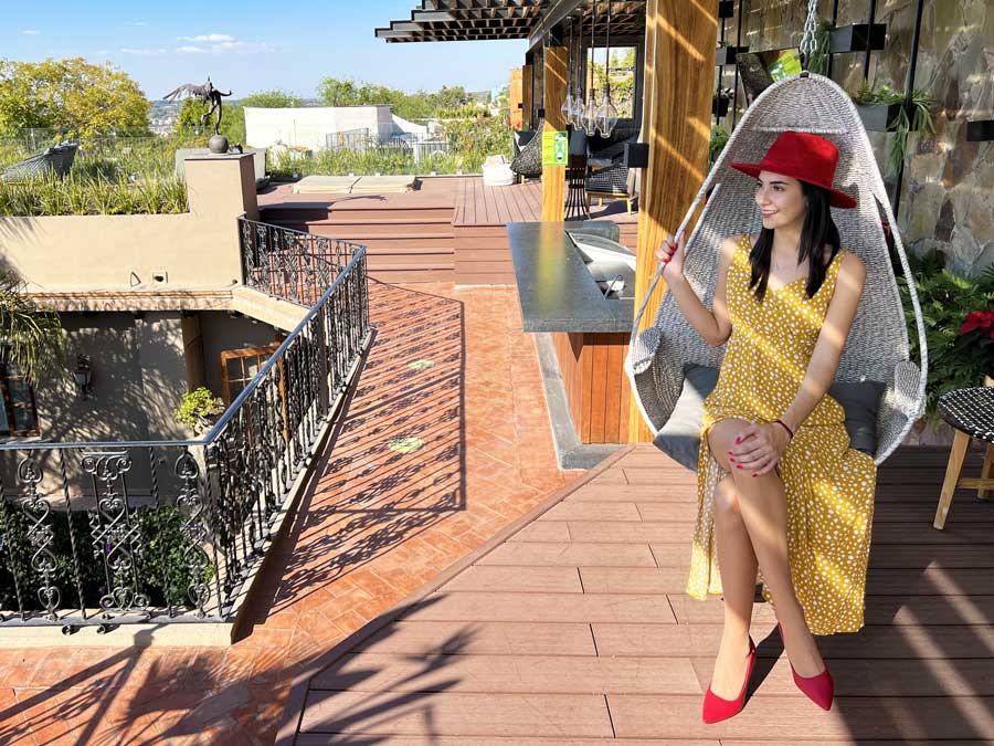 Clara sitting on a hanging chair in Hotel Mansion