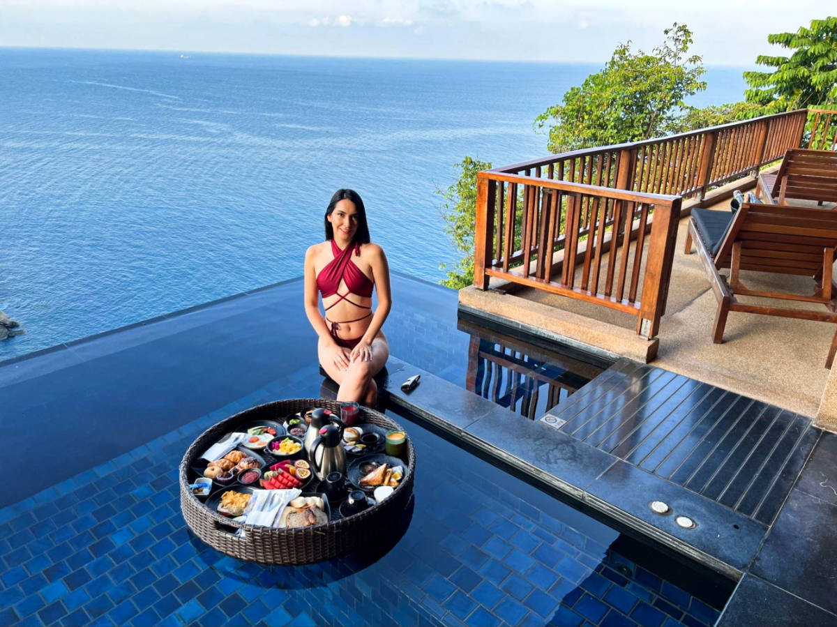 The author's partner, Clara, sitting on the poolside with a floating breakfast at Paresa Resort