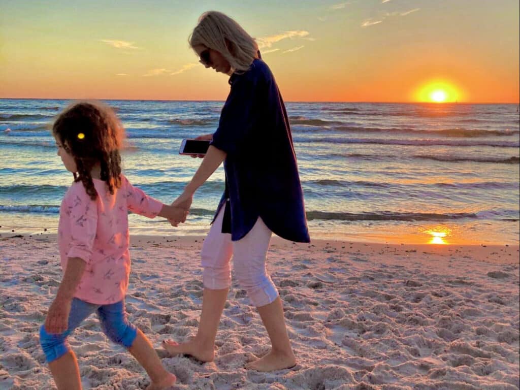 The author Claudicet Peña and her daughter, on a sunset beach walk in Cape Cod