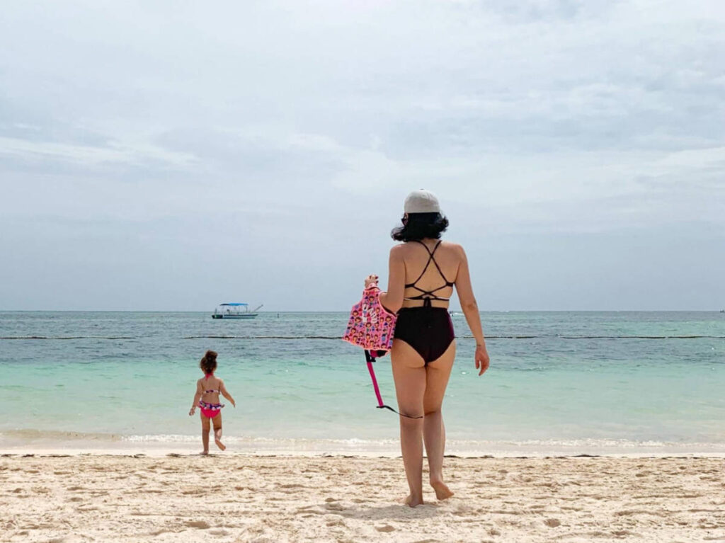 The author Claudicet Peña and her daughter walking along the shoreline
