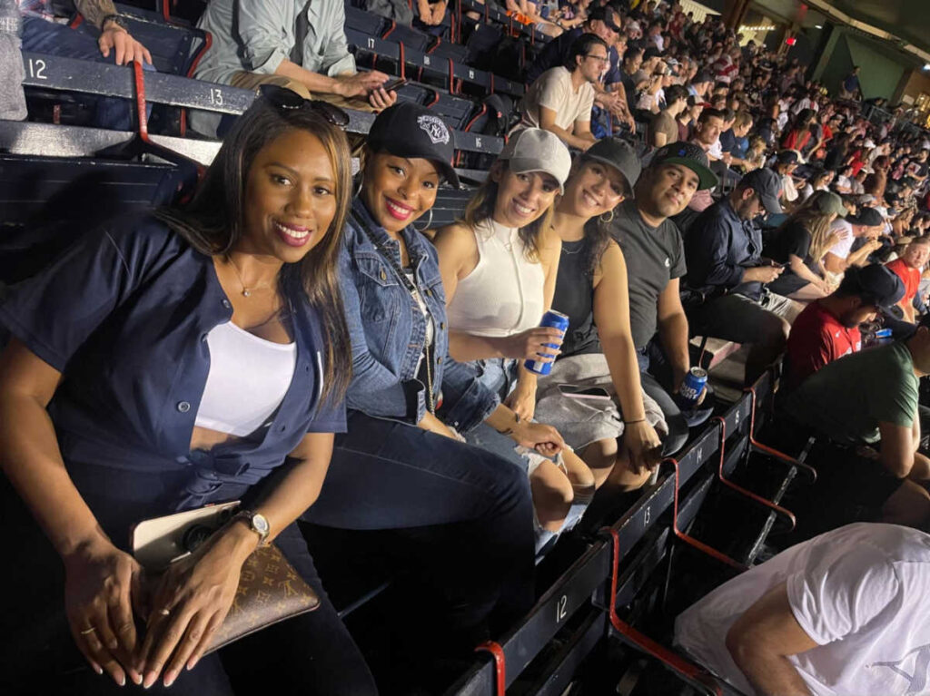 The author Claudicet Pena with her friends watching a Boston Red Sox game at Fenway Park