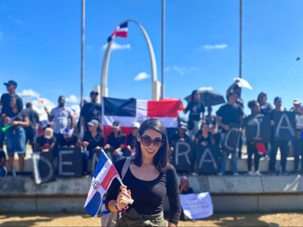 The author Claudicet holding a flag of Dominican Republic at Plaza de la Bandera