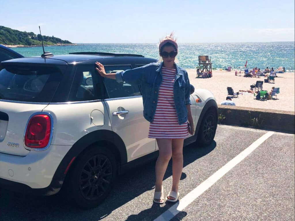 The author Claudicet Pena, posing near the car with the beach in the background