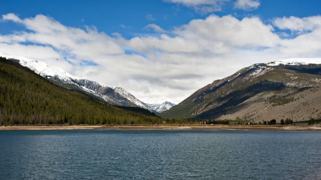 Panoramic view of the mountains with melting snow on the peaks in Clear Creek Reservoir