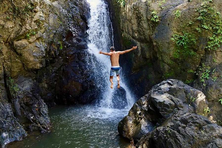 A man jumping on a cliff into the water in El Yunque